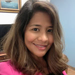 A woman with long hair wearing pink shirt.